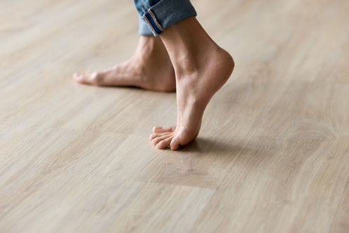 Henkilö kävelee paljain jaloin lämmitetyllä lattialla